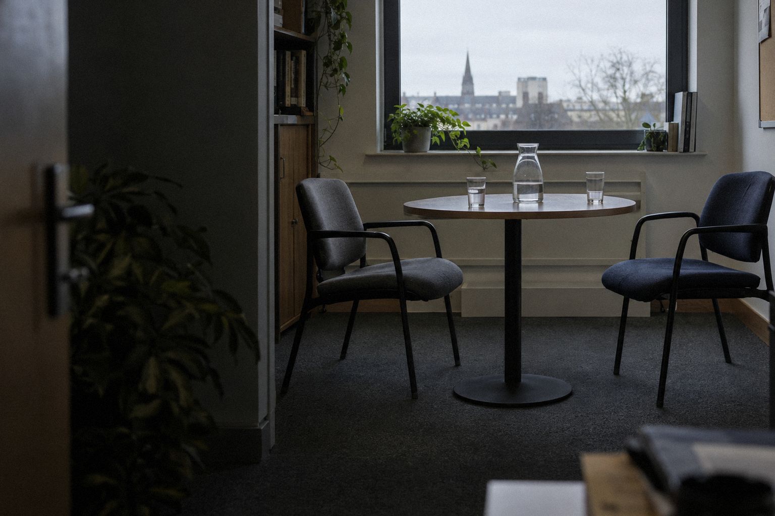 Two empty chairs facing each other across a small meeting table.