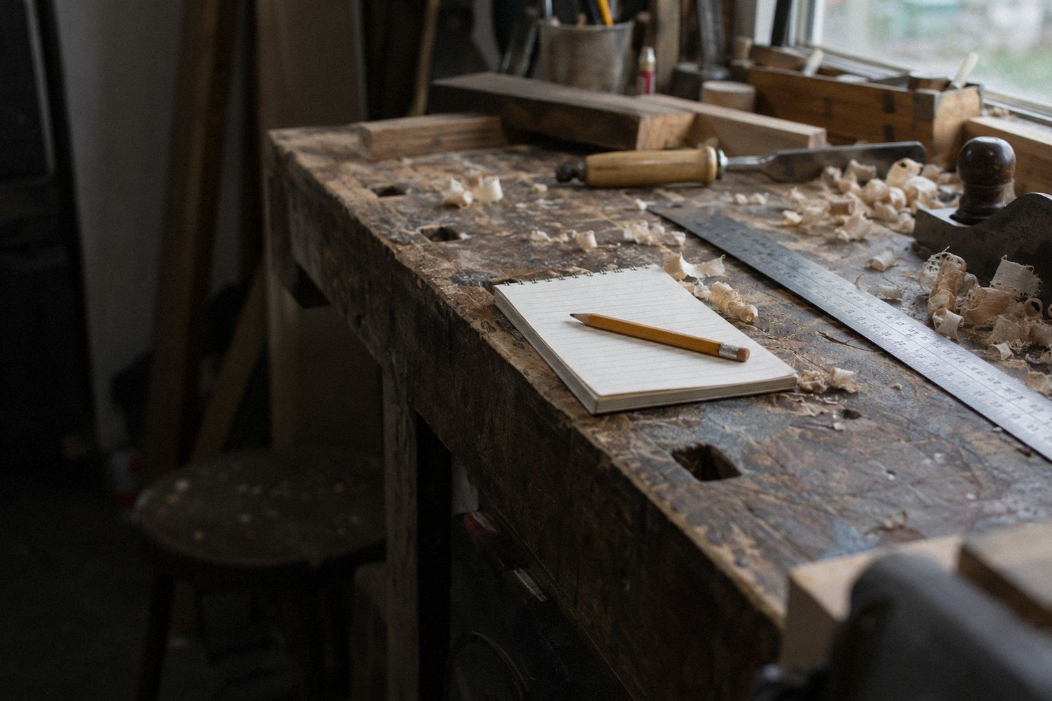 A quote pad and a pencil on a workbench in morning light.