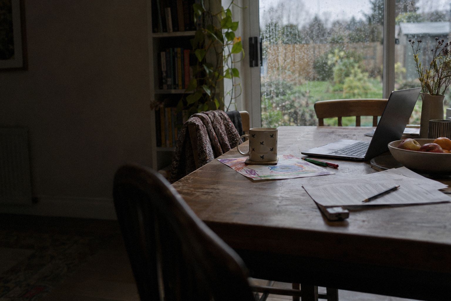 A kitchen table on a Sunday afternoon, a printed document beside a child's drawing.