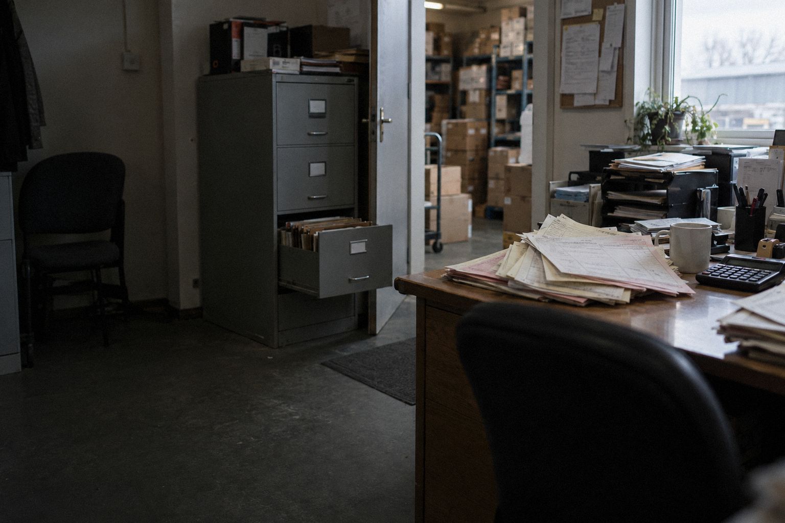 A wholesaler's back office on a Saturday, a filing drawer open and old invoices fanned out.