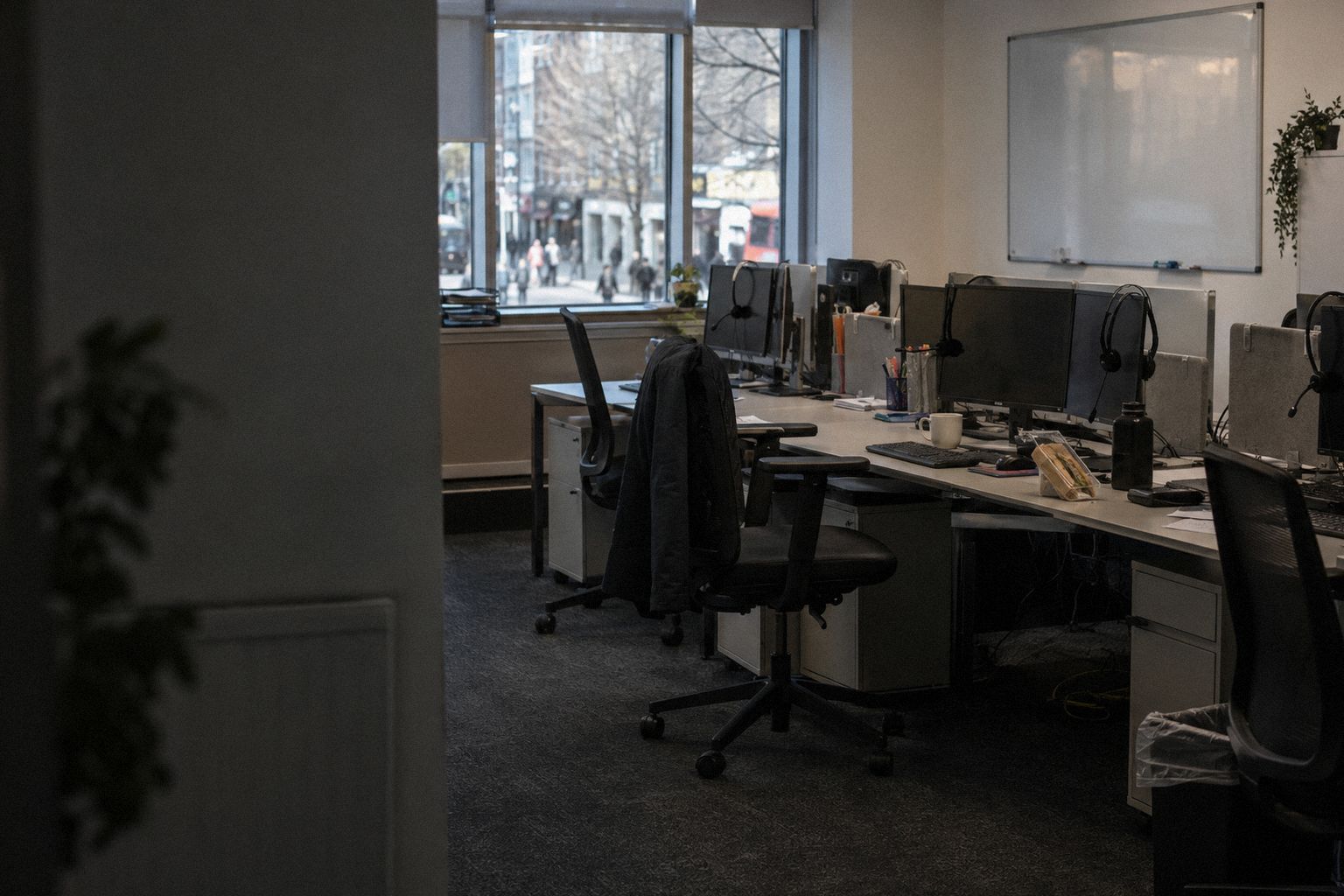 A recruitment office at lunchtime, headsets on the screens and the chairs empty.