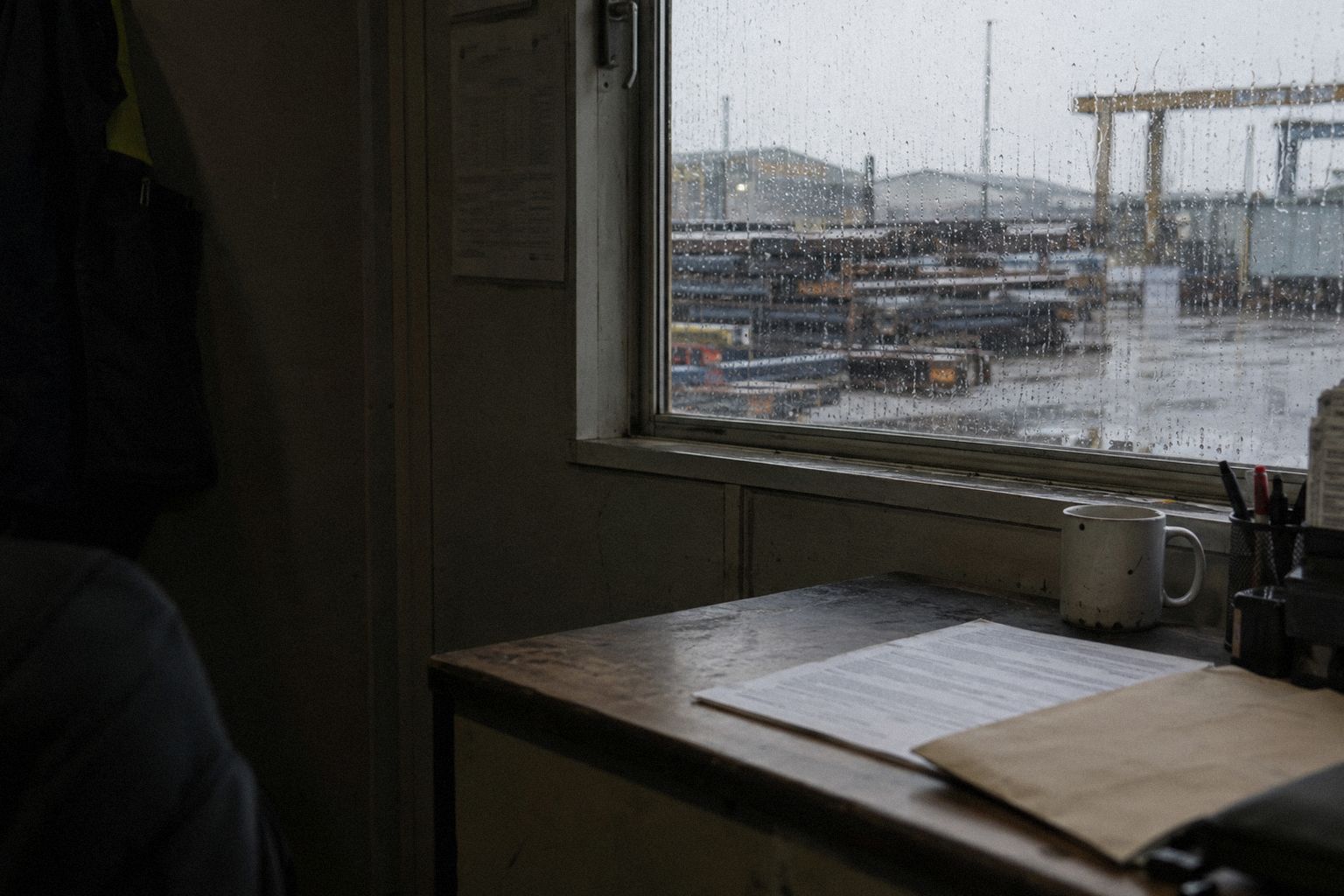 Rain on a yard office window on a Monday morning, a printed notice on the desk.