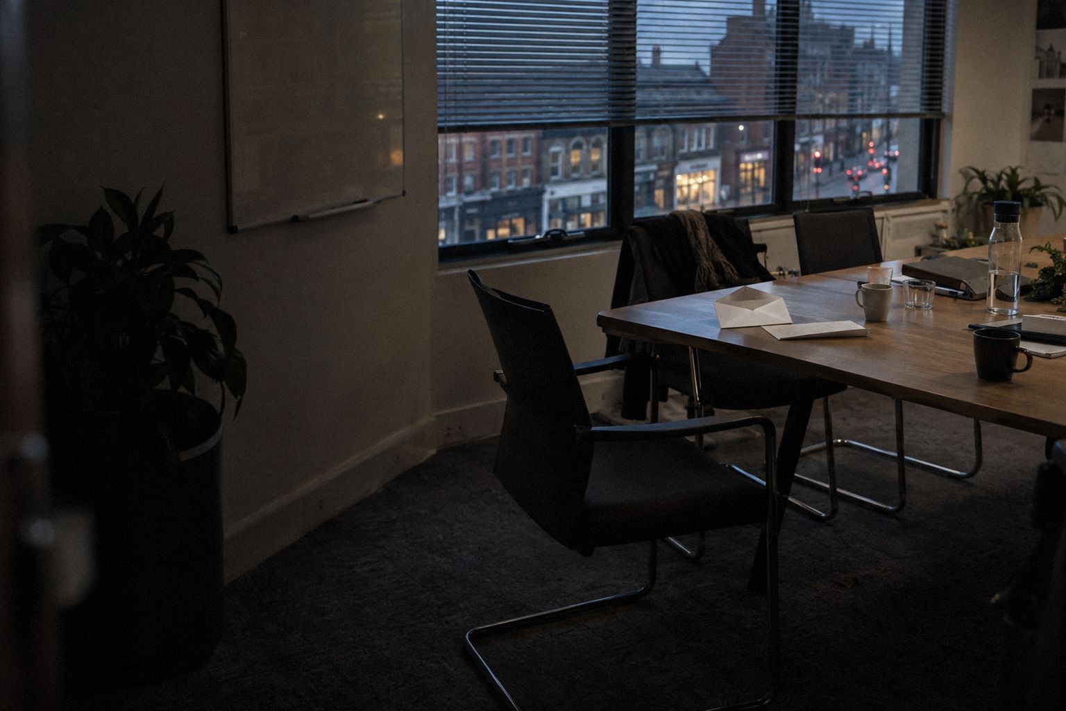 An agency meeting room after hours, an opened letter on the table.