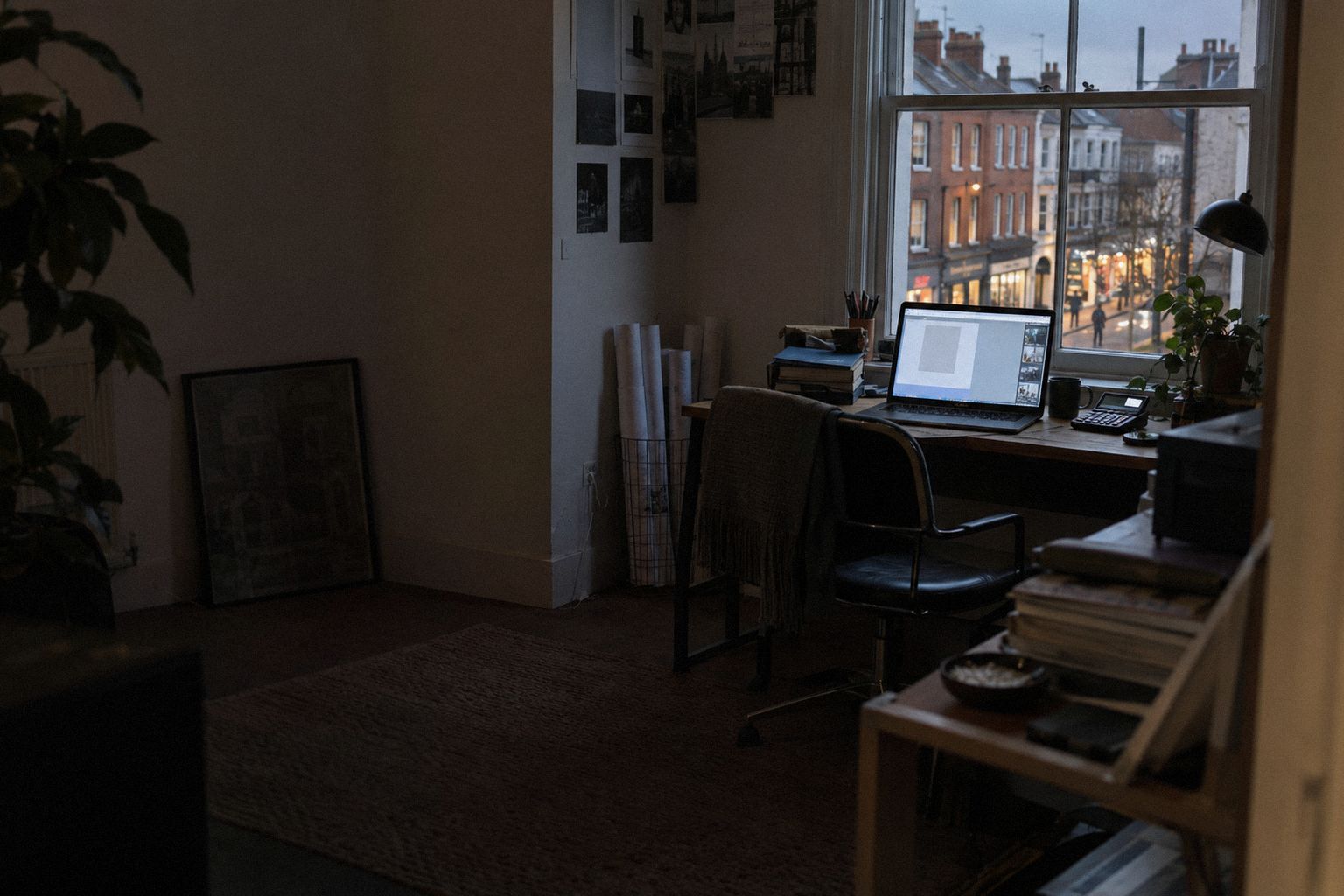 A studio above a shop at 6pm, the high street lights coming on below.