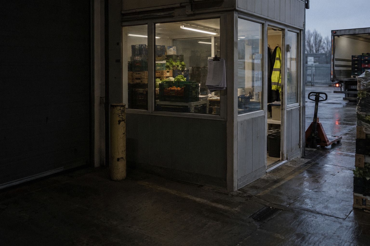 A catering wholesaler's office at 6am, crates stacked behind the glass.
