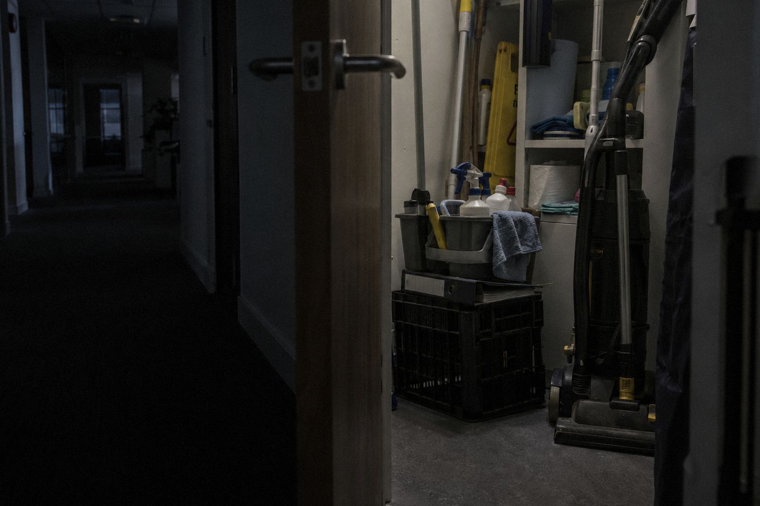 A cleaners' cupboard before dawn, a folder on an upturned crate.