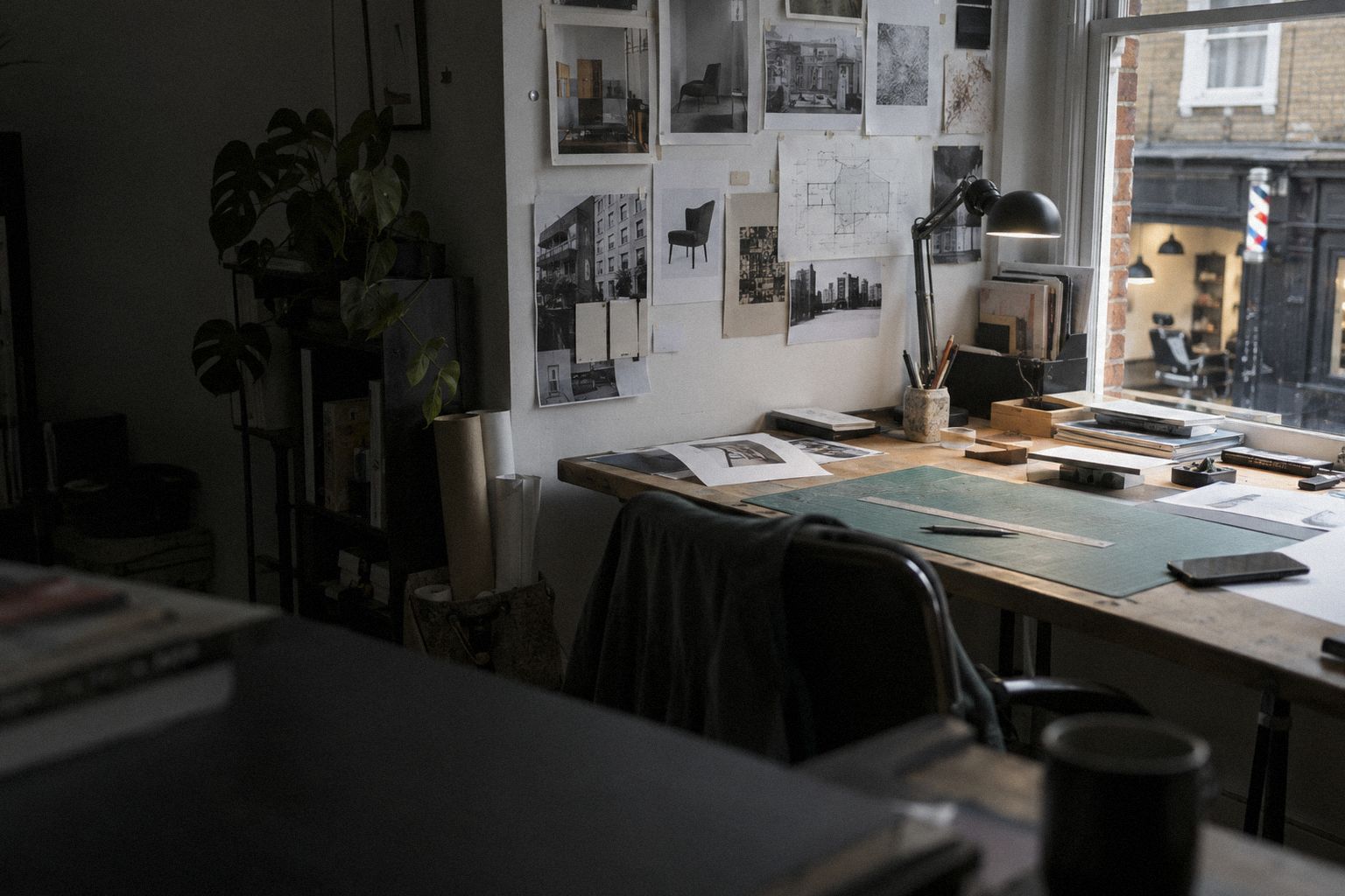 A design studio in late afternoon, a wall of pinned layouts.