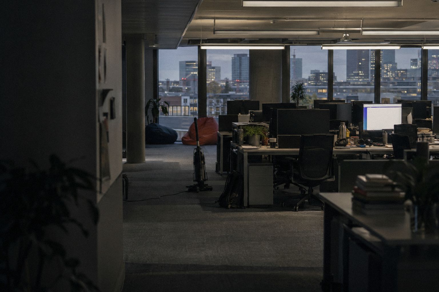An empty software office at 5.30pm on a Friday, a vacuum cleaner in the aisle.