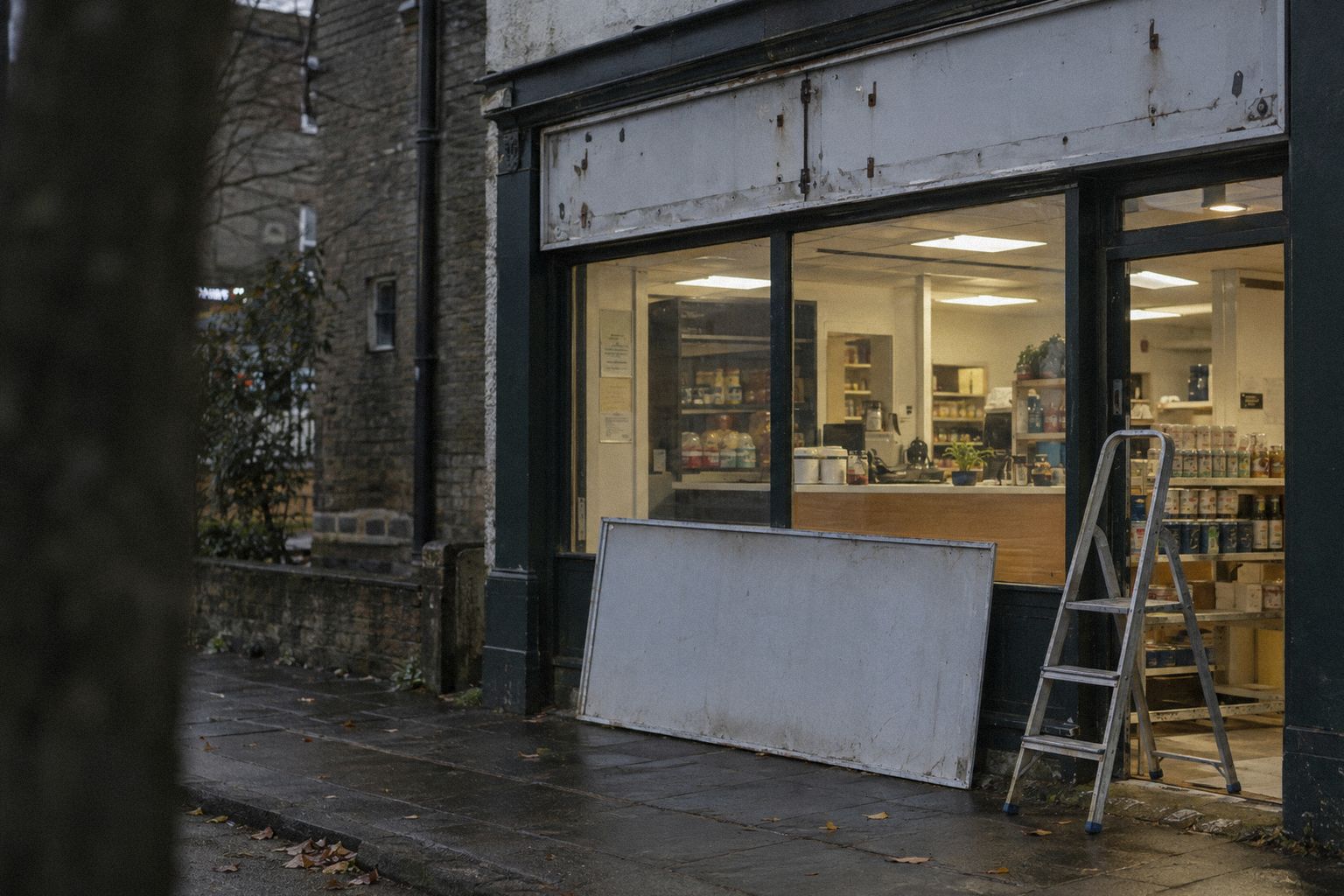 A shopfront at 8am, a blank sign board leaning against the window.