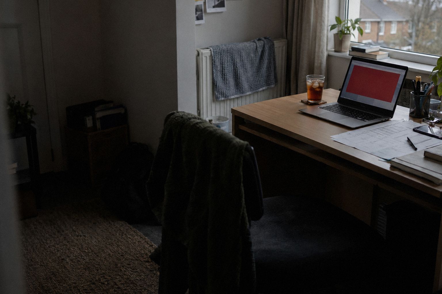 A spare-room desk at 4pm, a laptop showing a red warning panel.